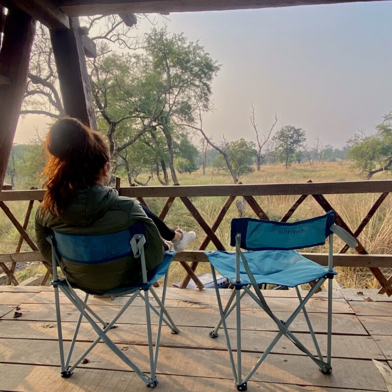 girl sitting on a chair looking at the grassland