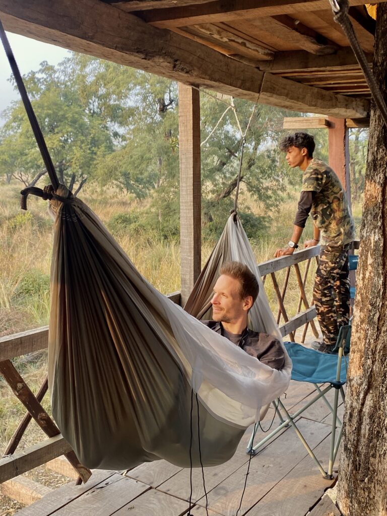 Guest taking rest in a hammock and wildlife guide