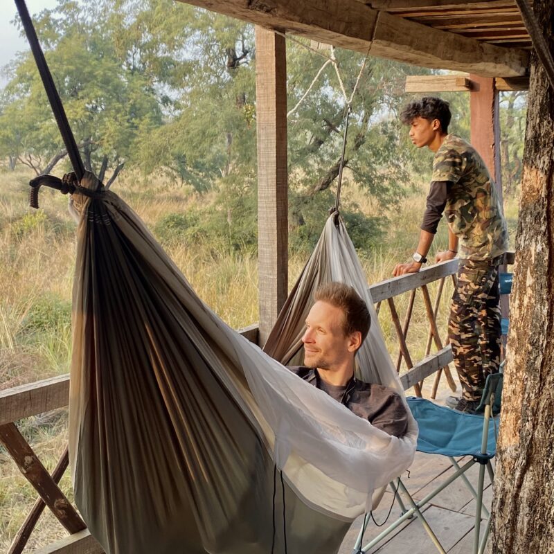 Guest taking rest in a hammock and wildlife guide