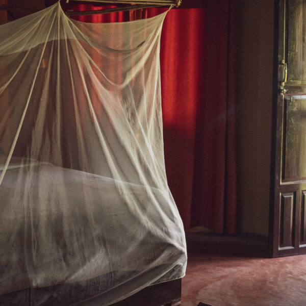 Bedroom with mosquito net at the bed and thick curtains